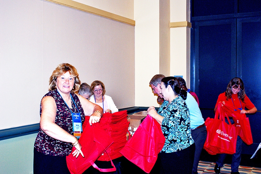 DSC03602.JPG - Nancy Thompson and others with Evercare prepare their give-away bags for the Welcome Reception in the exhibit hall, which they sponsored.
