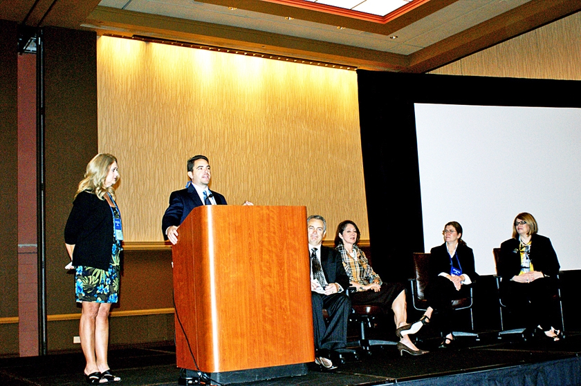 DSC03750.JPG - FL-ASCP Executive Director Brad Kile (at podium) thanks FMDA on Saturday morning, for 10 years of collaboration on the Best Care Practices conference, while FL-ASCP President Janet Dallman (from left), FMDA President Hugh Thomas, AGS Chairman Dr. Cheryl Phillips, AMDA President-elect Dr. Karyn Leible, and ASCP President Shelly Spiro look on.